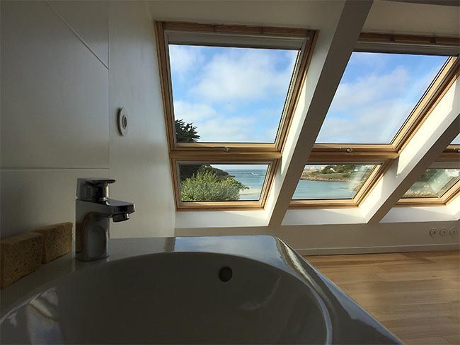 salle de bains avec velux en descente de toit donnant sur la mer