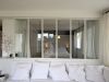 salon avec canapé donnant sur la chambre avec verrière