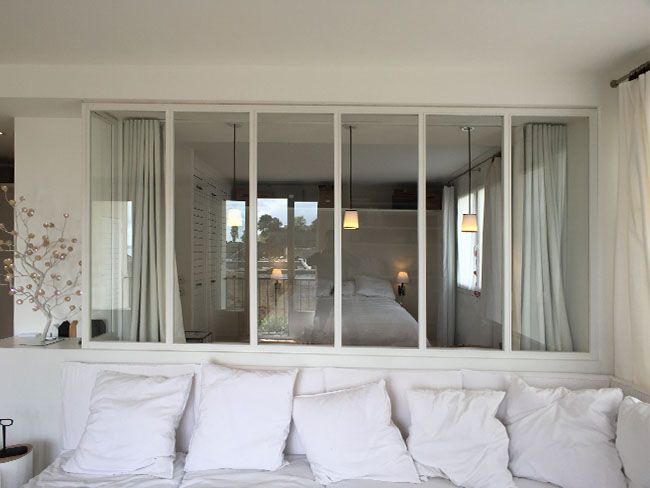 salon avec canapé donnant sur la chambre avec verrière